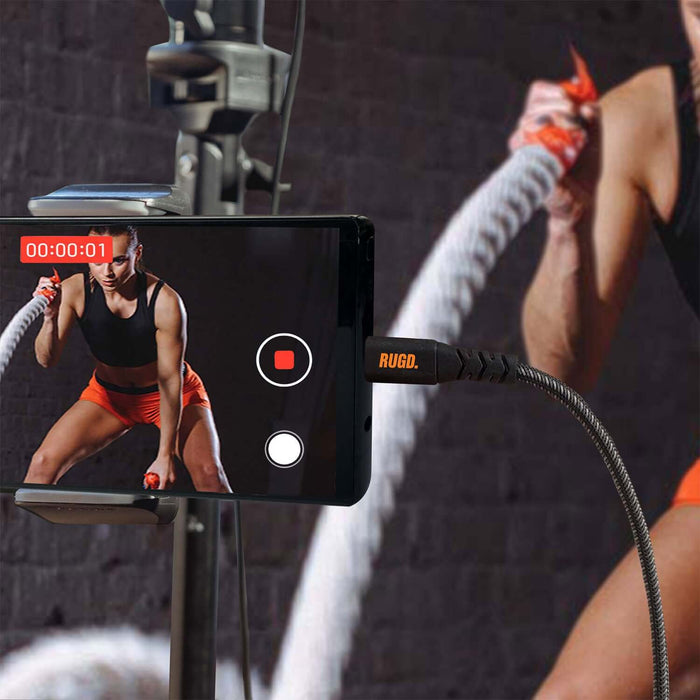 RUGD. Rhino Power USB-C to USB-C charging cable connected to a smartphone during a workout session.