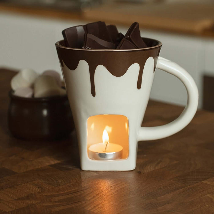 Chocolate Fondue Mug with melting chocolate, lit candle, and dipping treats, perfect for cozy evenings.