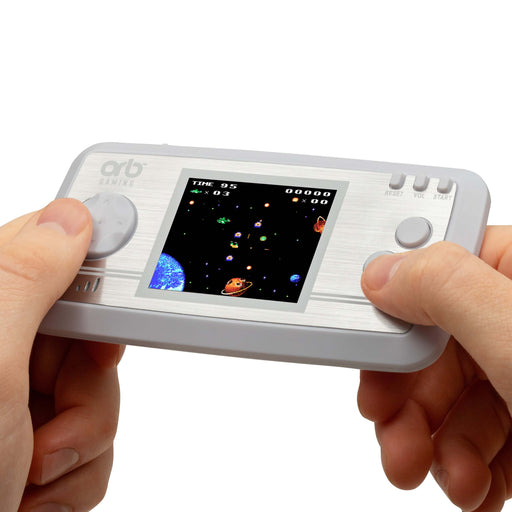 User holding Orb Retro Mini Handheld Games Console with 2.5-inch screen displaying classic space game.