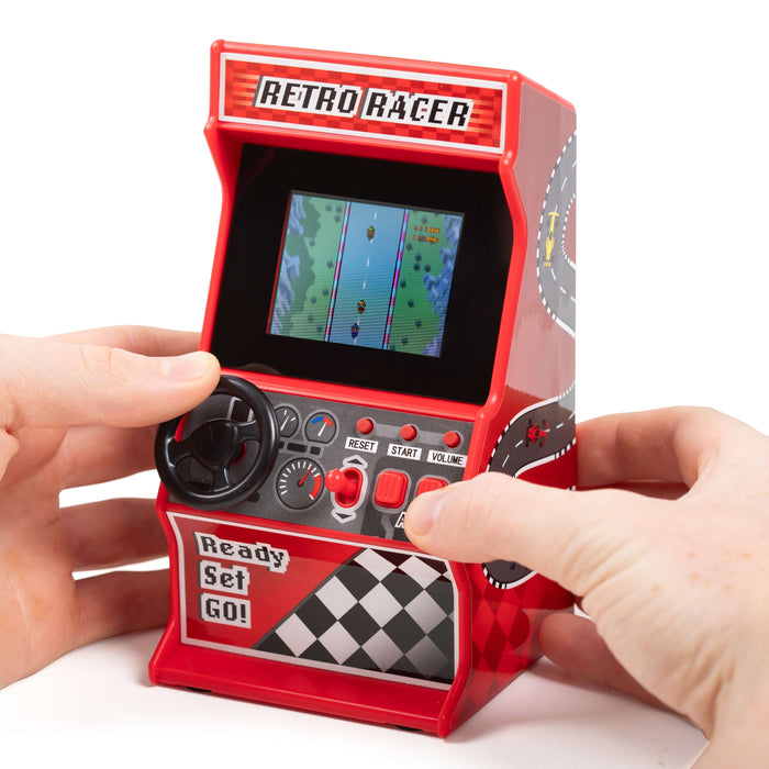 Hands playing Retro Mini Racing Arcade Machine with 30 games, featuring a classic steering wheel and vibrant screen.