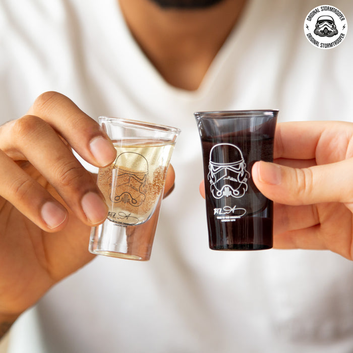 Person holding two Original Stormtrooper Shot Glasses, one clear and one black, showcasing their galactic design.