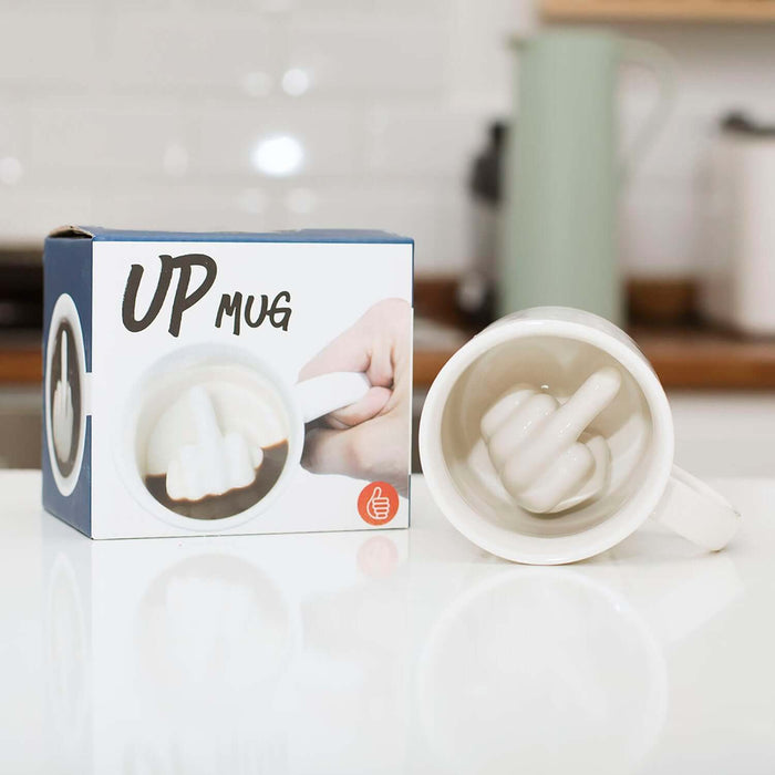 Up Yours 'Prank' Mug showing a white mug with a hidden hand gesture inside, displayed with its packaging.