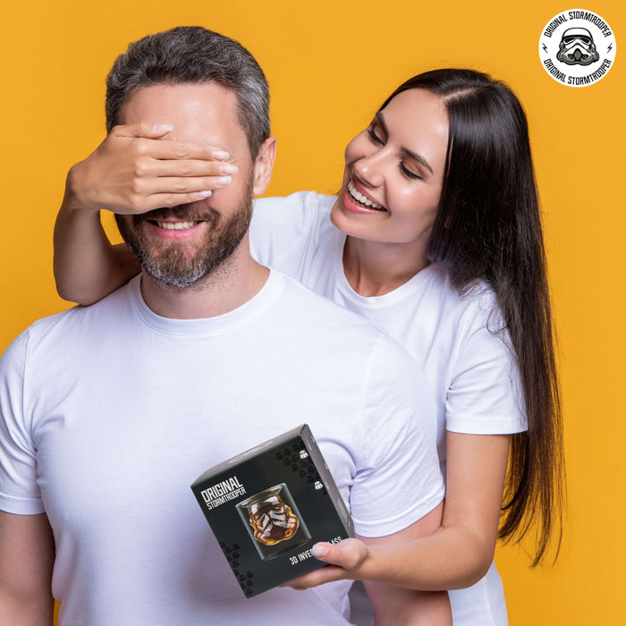 Couple holding Original Stormtrooper 3D Inverted Whiskey Glass gift box with orange background