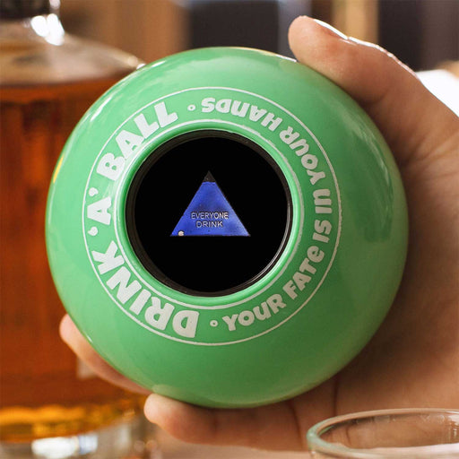 Hand holding a green Magic 8 Ball (Drink-a-Ball) revealing the command 'Everyone Drink' for party fun.