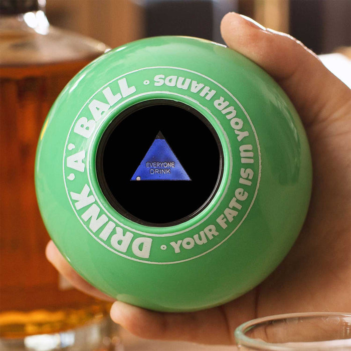 Hand holding a green Magic 8 Ball (Drink-a-Ball) revealing the command 'Everyone Drink' for party fun.