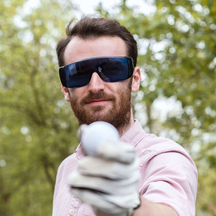 Golf Ball Finder Glasses (Classic Edition) worn by a man holding a golf ball outdoors, showcasing stylish and functional design.
