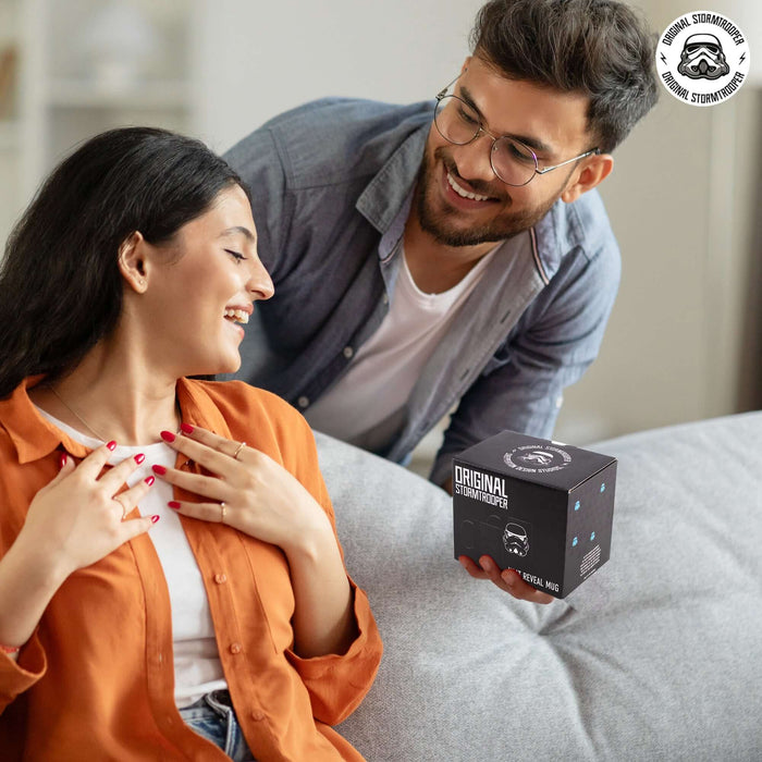 Couple enjoying time together with the Original Stormtrooper Colour Changing Mug packaging on the couch.