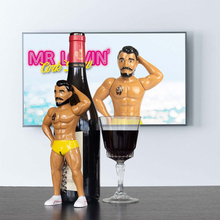 Mr. Lovin' Cork Screw in yellow shorts beside wine bottle and glass, adding flair to wine accessory collection.