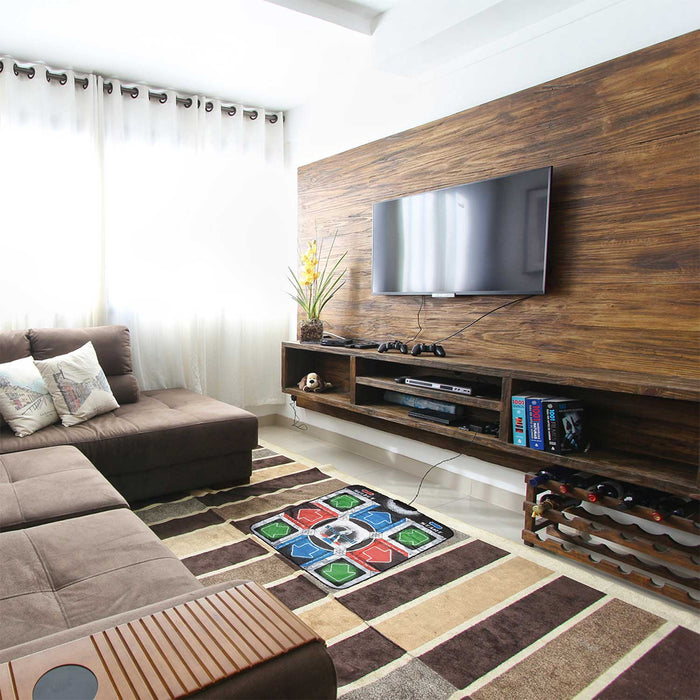 Living room with brown sofa, TV mounted on wooden wall, and Orb Retro Arcade Dance Mat on a patterned rug