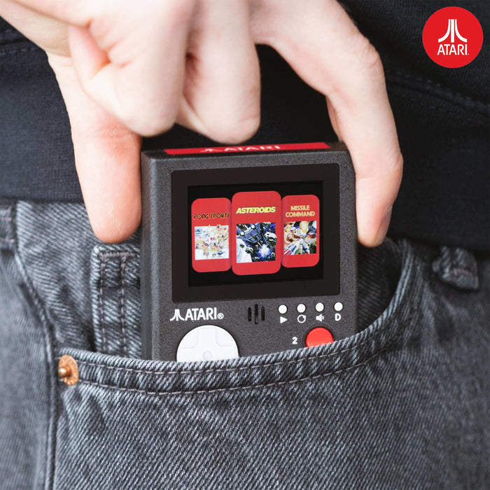 Atari handheld console in pocket, showcasing vibrant LCD screen with classic games: Pong, Asteroids, Missile Command.