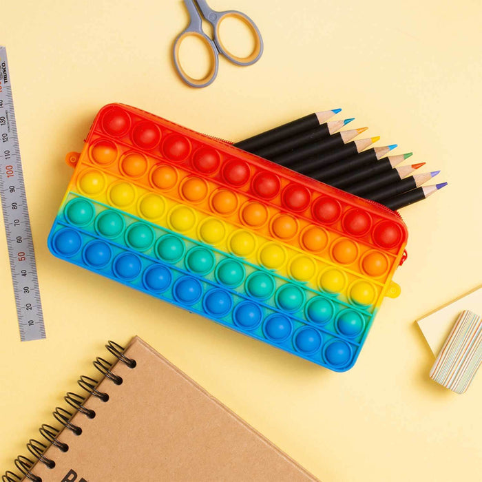 Rainbow Poppit Pencil Case with stationery items on a desk, perfect for stress relief and organization.