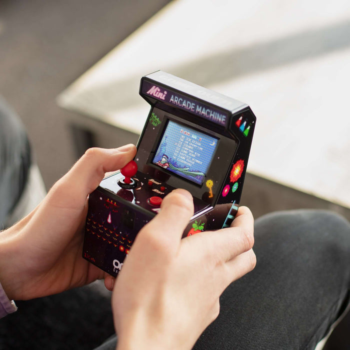 Man playing mini retro arcade machine