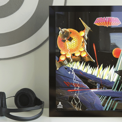 Framed Atari Pong cartridge artwork displayed on a shelf with headphones beside it
