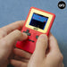 Hands holding the Orb Retro Mini Handheld Games Console (150-in-1 Games) with red casing and LCD screen.