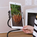 Adjustable tablet holder securing a tablet displaying a photo of fresh carrots in a kitchen setting.