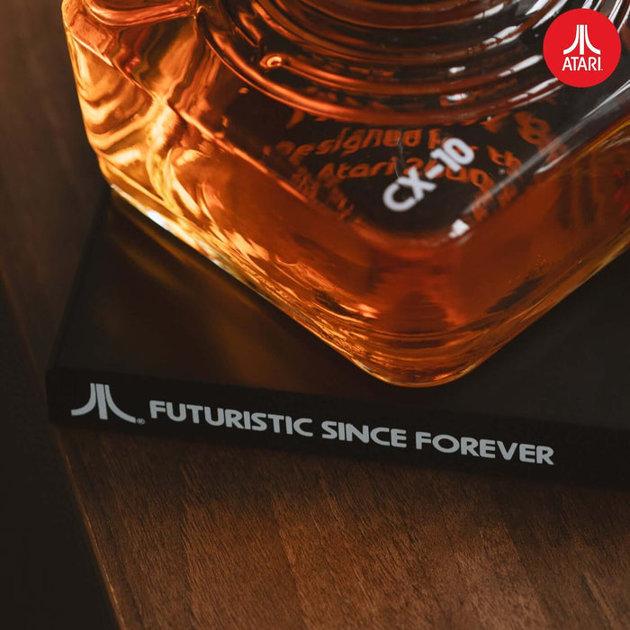 Close-up of Atari joystick decanter featuring CX-10 design and "Futuristic Since Forever" slogan on a stylish tray.