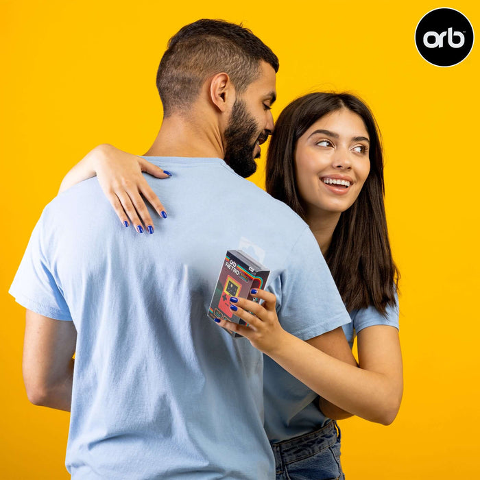 Young couple smiling while holding the Retro Mini Handheld Games Console (150-in-1 Games) against a bright yellow background.