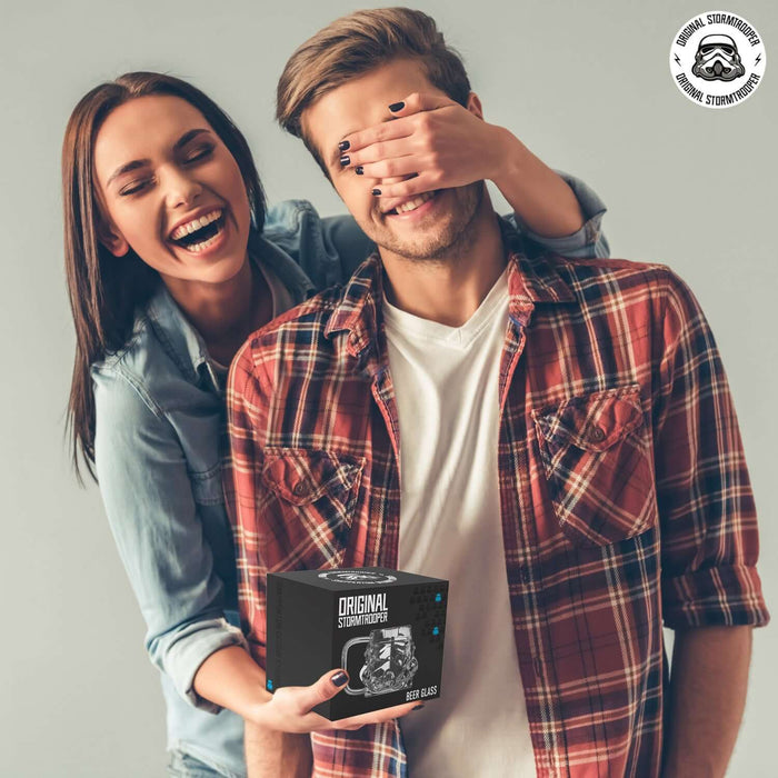 Couple holding Original Stormtrooper beer glass packaging, celebrating with laughter.