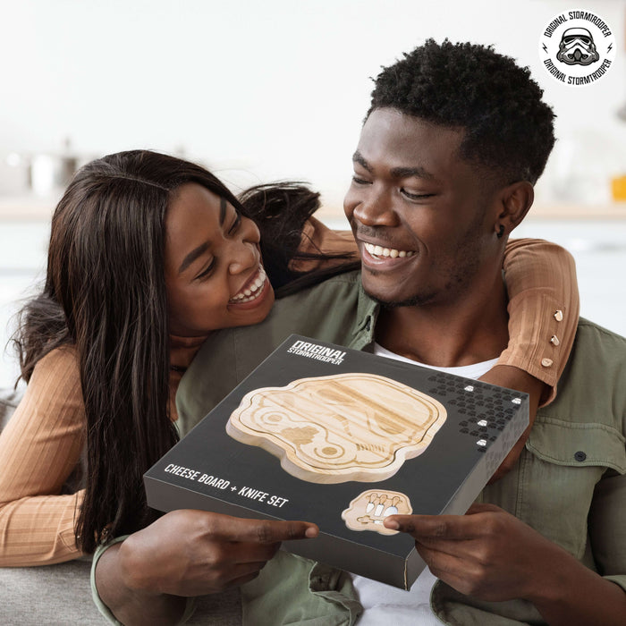 Couple smiling and holding an Original Stormtrooper 3D Cheeseboard with knife set, perfect for Star Wars fans and cheese lovers.