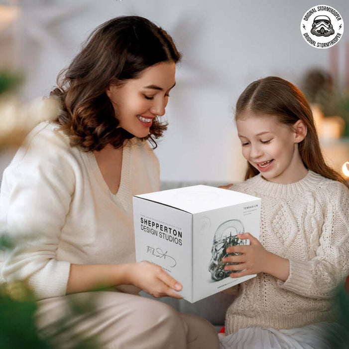 Mother and daughter unboxing the Original Stormtrooper Terrarium & Cookie Jar together in a cozy setting.