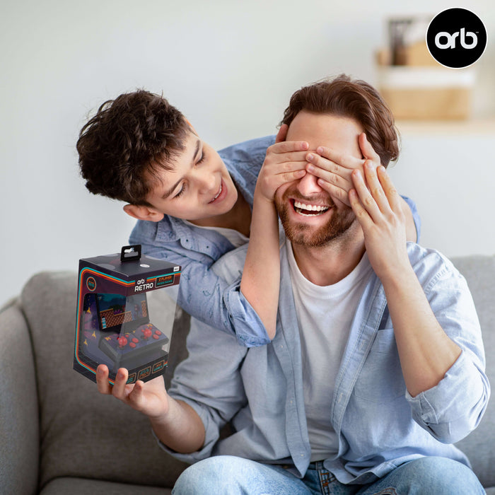 Two friends enjoying the Orb Retro Mini Arcade Machine, with one person covering the other's eyes while holding the product.