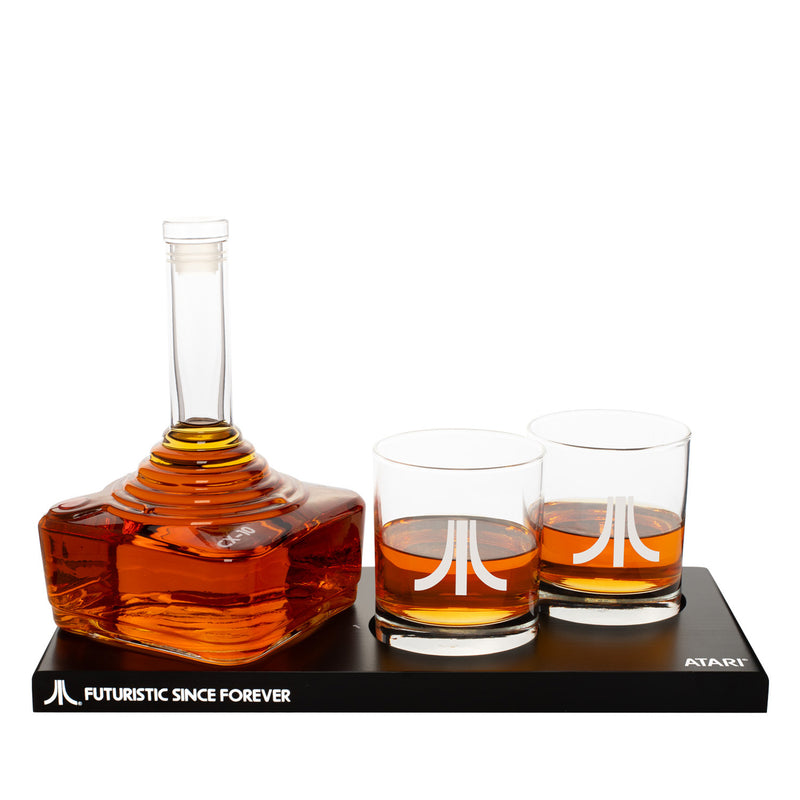 Atari decanter and whiskey glass gift set by ThumbsUp, retro gaming-inspired barware with engraved logo and modern display stand.